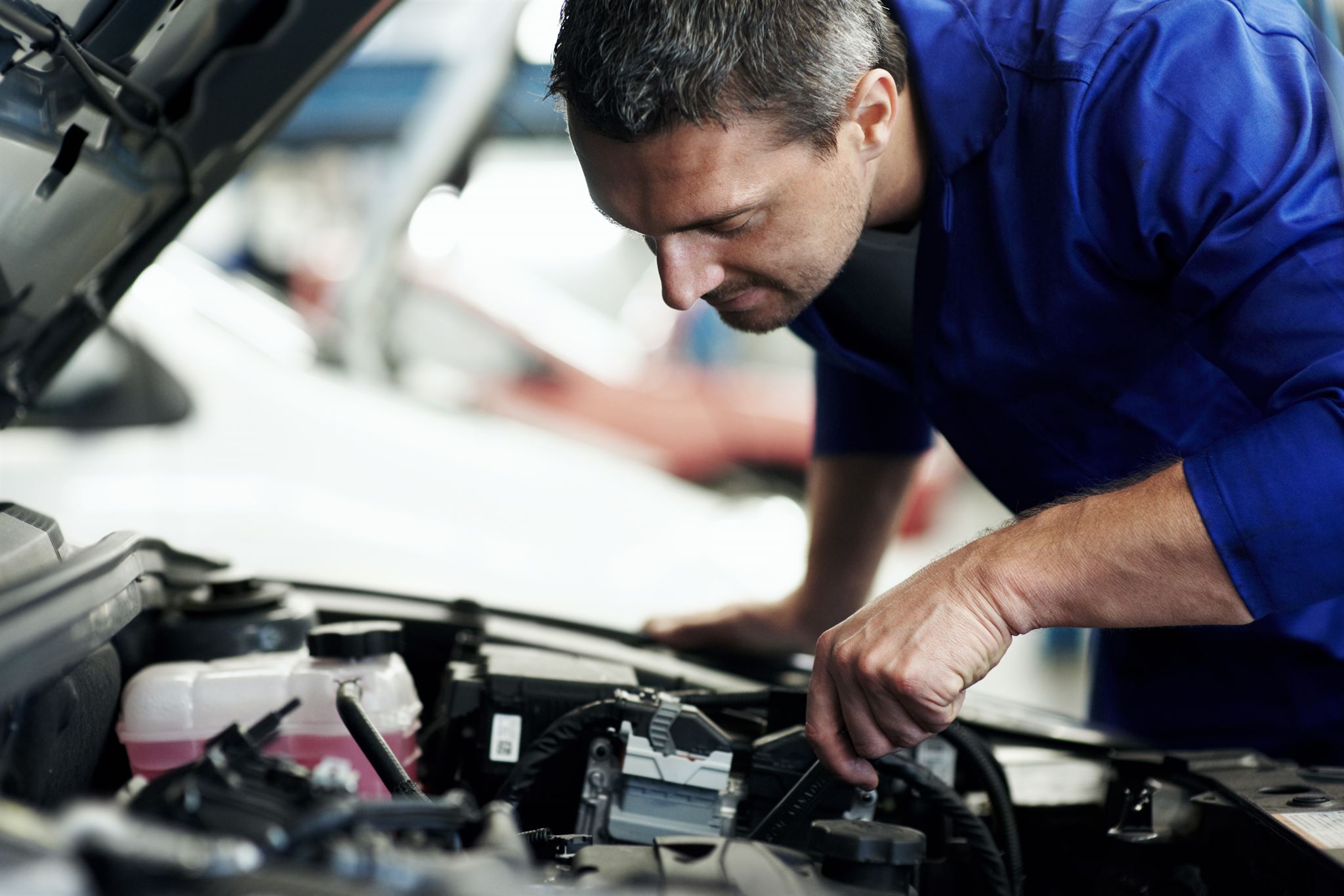 Person inspecting car engine